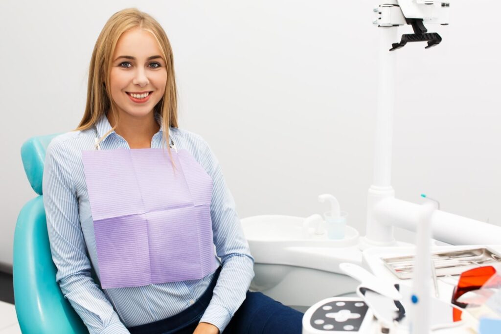 Vodič kroz Iskustvo sa Kompozitnim Fasetama za Zube happy-woman-sits-chair-dentist-office